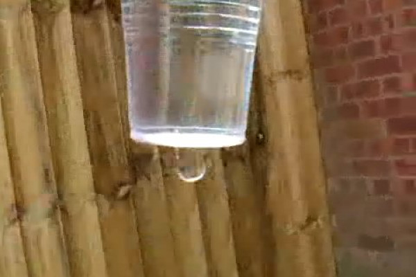 The cup dropping, showing how the flow of water stops.