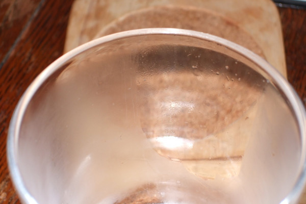 A glass that has had one area covered in diluted washing up liquid and then it was breathed on