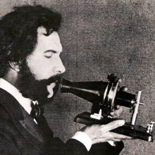 Alexander Graham Bell speaking into a prototype telephone