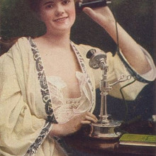 Woman using telephone, c. 1910.