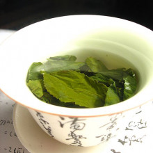 Green tea leaves steeping in an uncovered zhong (type of tea cup).