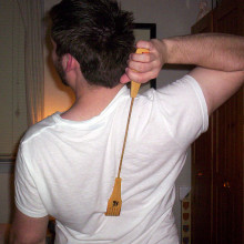 Man scratching back with a Backscratcher