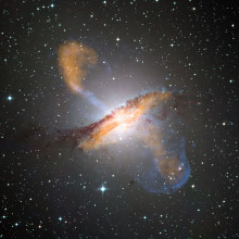 This composite of visible, microwave (orange) and X-ray (blue) data reveals the jets and radio-emitting lobes emanating from Centaurus A's central black hole.