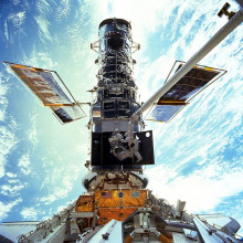  Astronauts Steven L. Smith, and John M. Grunsfeld, appear as small figures in this wide scene photographed during extravehicular activity (EVA). On this space walk they are replacing gyroscopes, contained in rate sensor units (RSU), inside the Hubble...