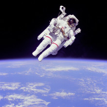  Astronaut Bruce McCandless II, mission specialist, participates in a extra-vehicular activity (EVA), a few meters away from the cabin of the shuttle Challenger. He is using a nitrogen-propelled hand-controlled manned manoeuvring unit (MMU). He is...