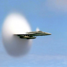 An F/A-18 Hornet breaks the sound barrier in the skies over the Pacific Ocean.