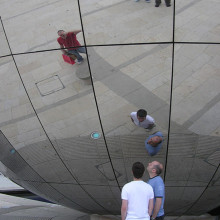 Spherical mirror in Millennium Square, Bristol, England. The photographer is seen top right in the blue shirt. The mirror forms the side of the Explore-At-Bristol Planetarium sphere.