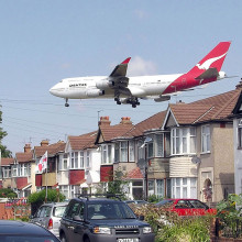 A Qantas Boeing 747-400 approaching runway 27L at London Heathrow Airport, England. The houses are in Myrtle Avenue, at the south east corner of the airport.