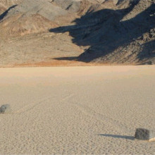 Picture of two rocks on Racetrack Playa in Death Valley. Notice the mysterious groves leading away from the stones.