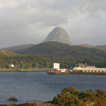  Suilven Caisteal Liath above Lochinver. The 'sugar loaf' Caisteal Liath buttress of Suilven dominates the skyline above Lochinver. This view over the fishing port was taken from the Baddidarach side of Loch Inver. The ornate building by the harbour...