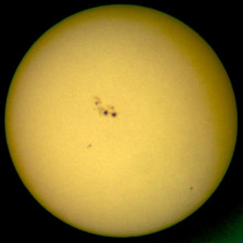  Ocular projection of the sun with large sunspots using a spotting scope (50mm diameter, 45x magnification) and a sheet of paper approx. 30 cm from the ocular. The apparent granulation is due to that of the paper rather than the photospheric...