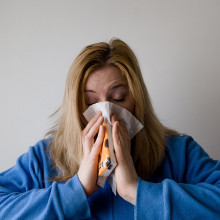 A woman blowing her nose