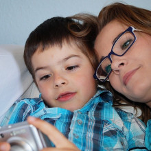 A mother and her son looking at photos on a camera.