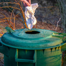 Throwing away a paper towel in a bin.