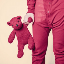 person in pink pyjamas holding pink teddybear