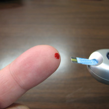 a photo of finger prick blood test for blood glucose monitoring
