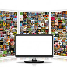 A blank computer monitor in front of a wall of images.