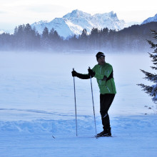 A skier stands on a frosty ski slope.