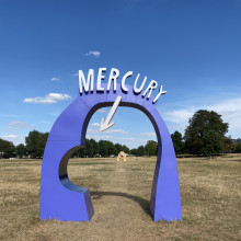 Purple arch with the word "Mercury" on top pointing to a tiny pea-sized planet