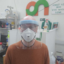 A Makespace volunteer wearing a plastic face visor.