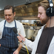 Chef Tristan Welch holding a haggis while Phil Sansom holds a microphone to his mouth