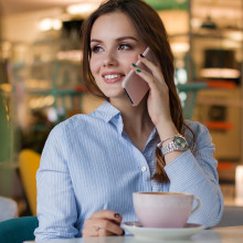 Woman speaking on a mobile phone over coffee