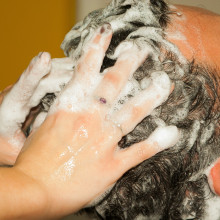 a hairdresser washing someone's hair with shampoo