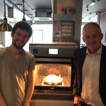this is a picture of 2 men standing next to an oven