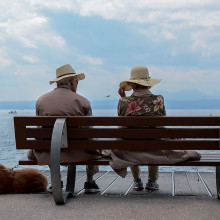 Two people on a bench by the sea