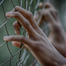 Hands on a fence