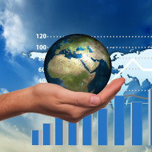 Hand holding the earth with generic graphs behind