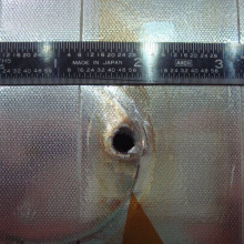  Image of the entry hole created on Space Shuttle Endeavour's radiator panel by the impact of unknown space debris.