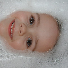 Face surrounded by bubbles in a bath