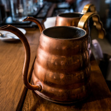 Two brass vessels on a wooden table Two brass vessels on a wooden table