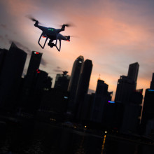 Silhouette of a drone flying over a city 