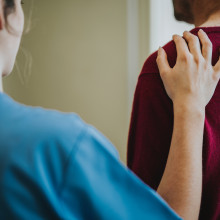 woman places hand on someone's back