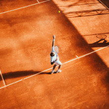 A tennis player throwing a ball in the air