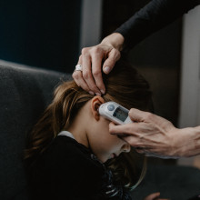 Taking a child's temperature with a digital ear thermometer