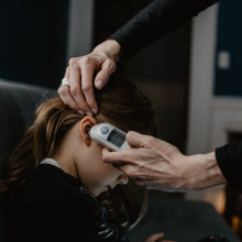 A child getting her temperature measured