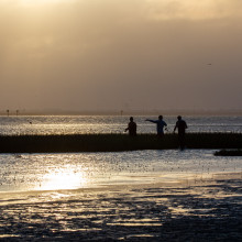 Fishermen on the horizon on the seashore