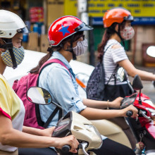 Girls riding motor scooters, wearning facemasks against air pollution