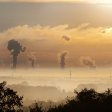 Polluted sky, silhouettes of trees and electricity pylons