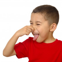 Kid smelling something bad and holding his nose
