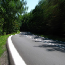 A photo taken from on the road while the trees blur due to speed