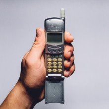 Image of a hand holding an old mobile phone