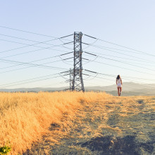An electric pylon sitting in the middle of a field