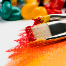 Paintbrushes dipped in yellow and red