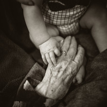 Young and old hands touching