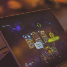A handheld tablet with Hearthstone on the screen