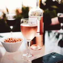 A glass and bottle of rose wine on a table